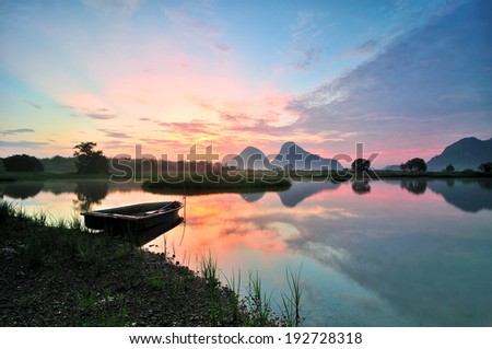Landscape of a boat by the lakeside during sunrise