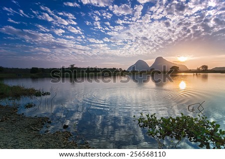 Reflection of beautiful nature landscape by the lakeside in tropical country during sunrise