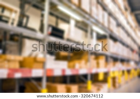 Blurred image inside a warehouse with multi-layer shelves.