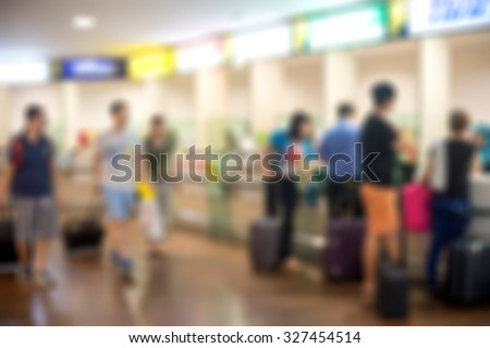 Blurred image of passengers at ticketing counter in airport terminal