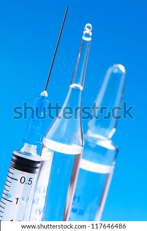 Disposable syringes and ampules on a blue background