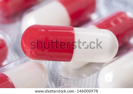 Red and white pills in package close up