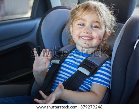 Little dirty girl , baby in a safety car seat. Safety and security