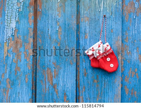 Red gloves on blue woody background