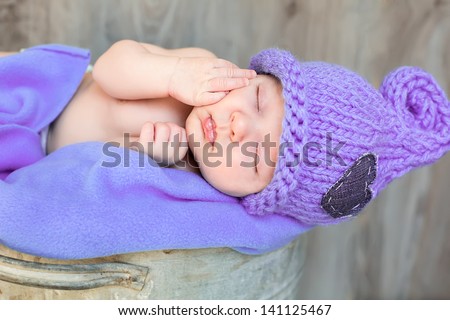The sweet dream of newborn in purple hat