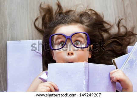 Cute girl in the glasses holding a purple book