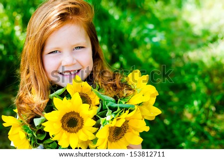 Red haired girl smiling with sunflowers in her hands