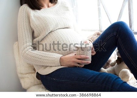 Pregnant woman with a cup in his hands