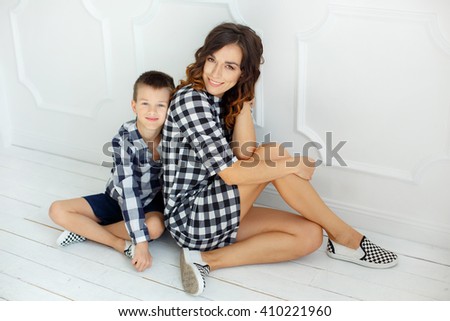 stylish guys in plaid dress posing to the camera. mom and son. amazing model. woman and boy