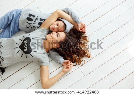 Mother and son lying on the floor holding each other and smiling