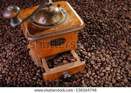 An old coffee grinder with a lot of coffee grain