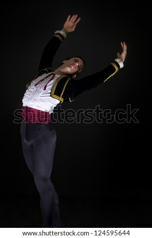 Male dancer in dramatic pose on black background