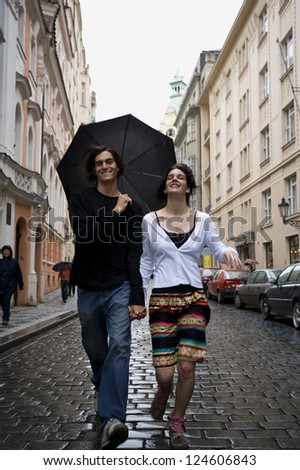 Motion Blur Shot of a Couple walking in rain holding hands