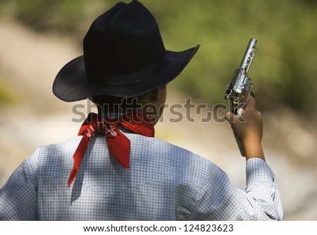 Little boy with toy gun playing outdoors