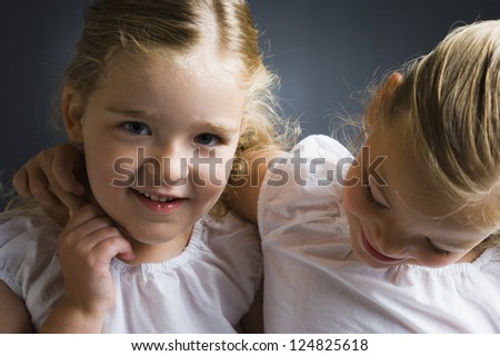 Portrait of two little sisters smiling at camera