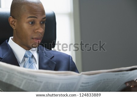 Portrait of African American man reading newspaper