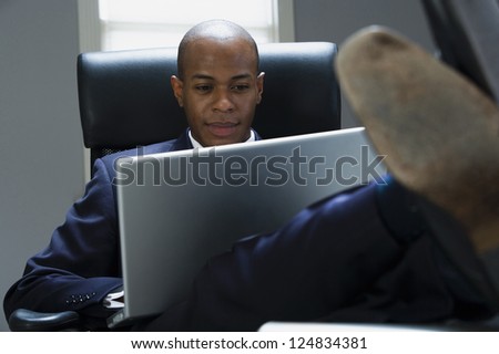 Portrait of African American man working with laptop in office