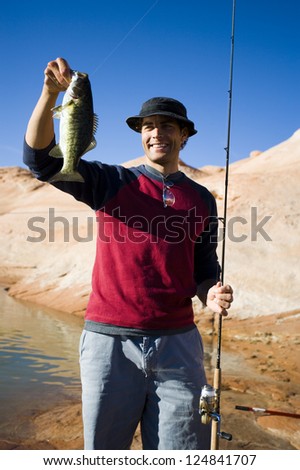 Happy fisherman holding fish