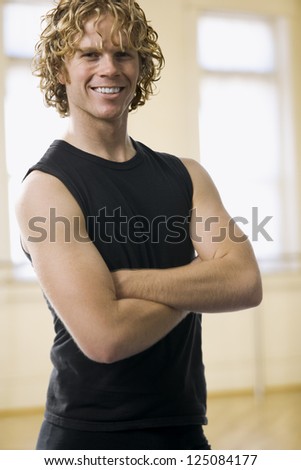 Male dancer posing and smiling in a rehearsal room