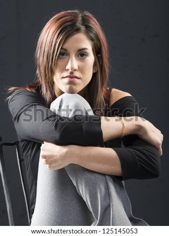 Young woman in chair leaning on knee