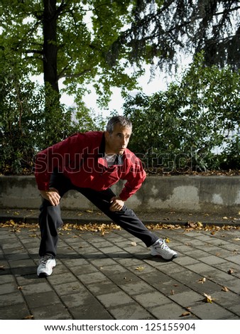 Full length of a male jogger stretching