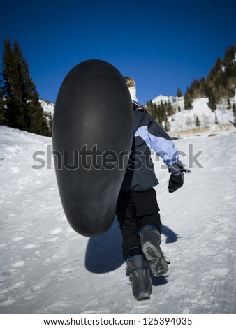 Motion rear view of a girl walking with inner tube