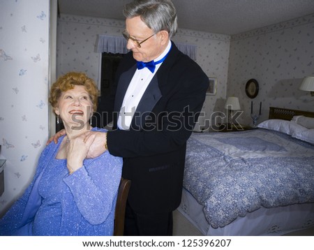 Elderly couple in formal wear in bedroom