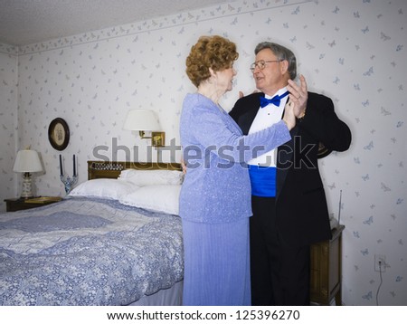 Senior couple dancing in their bedroom