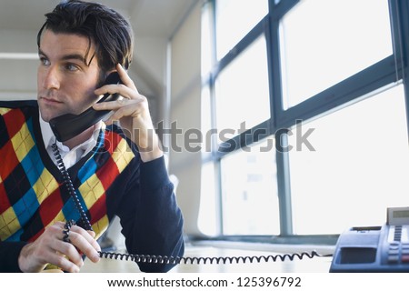 Worried young man holding phone receiver