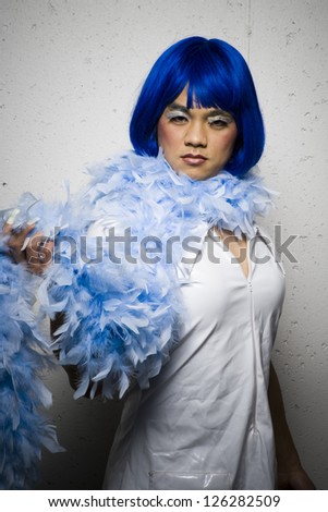 Portrait of man in blue wig and feather boa flirting