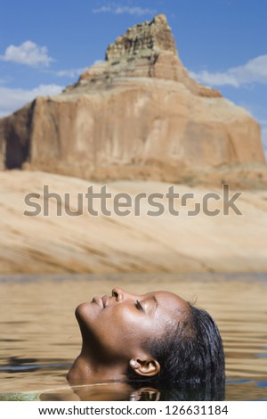 Women relaxing in water with mountain landscape in background