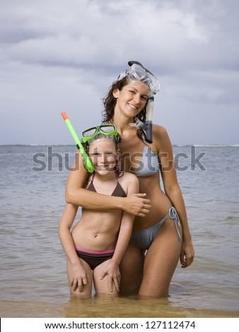 Mother and her daughter wearing scuba masks and snorkels