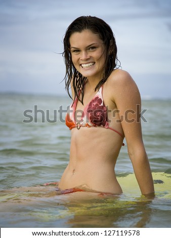 Portrait of a teenage girl floating on a boogie board in the sea