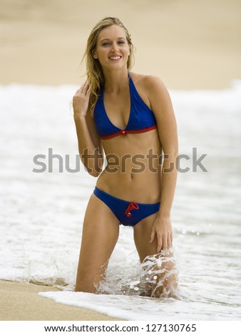 Portrait of a young woman kneeling on the beach