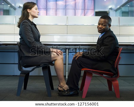 Businessman and a businesswoman sitting face to face