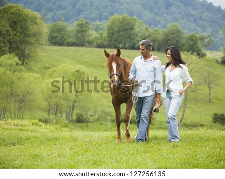 Man and a woman walking with a horse