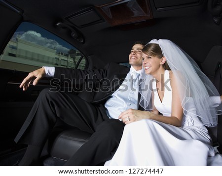 Just married couple sitting in a car and smiling