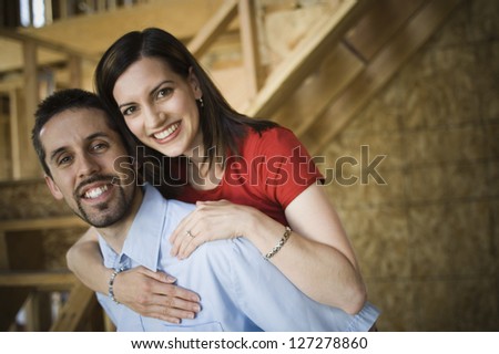 Portrait of a young woman embracing a young man from behind