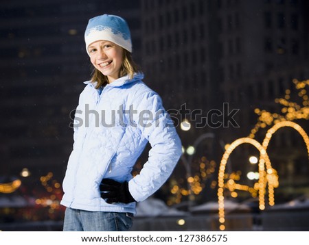 Girl with braces smiling outdoors in winter with hands on hips