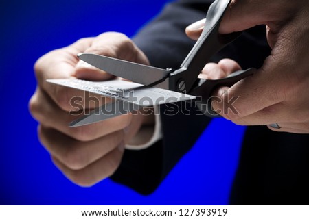 Man Cutting Credit Card over blue background