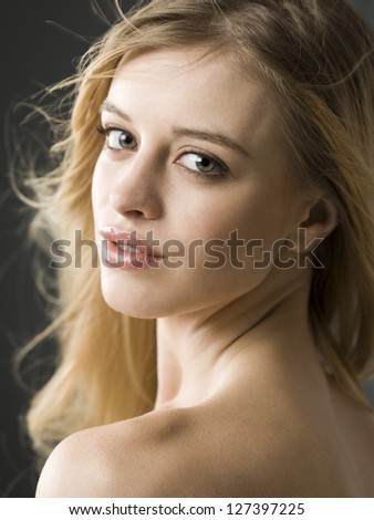 Portrait of a teenage girl with bare shoulder turning back
