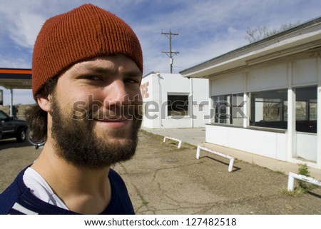 Man with toque and beard smiling with empty stores in the background
