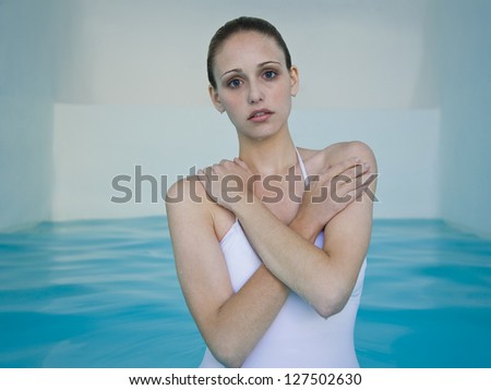 Drenched woman in pool with hands on shoulders