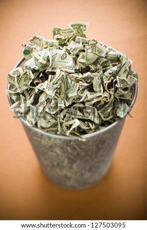 Waste paper basket with crumpled money