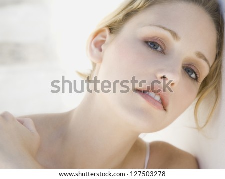 Close-up of a woman leaning her head on wall