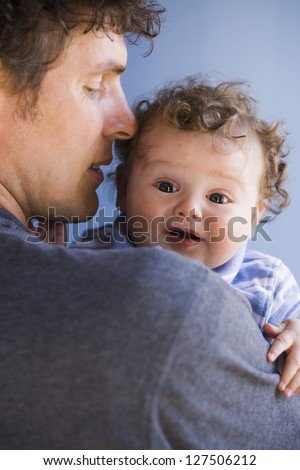 Man holding baby boy looking frightened
