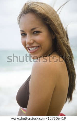 Woman in bikini smiling at the beach
