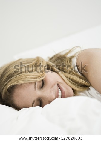 Woman lying down with closed eyes smiling