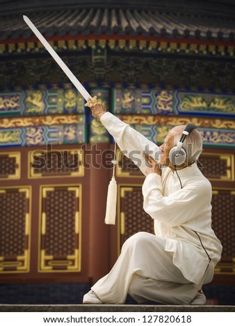 Man with sword doing Kung Fu with headphones
