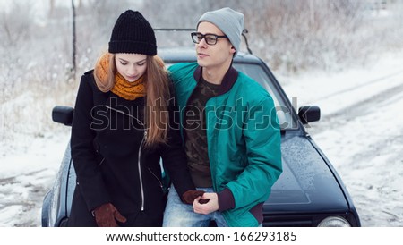 outdoor fashion portrait of young sensual couple in cold winter weather. love and kiss , car